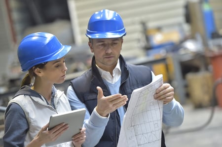 Engineers in mechanical factory reading instructions | Source: ESB Professional / Shutterstock 