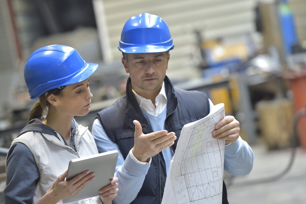 Engineers in mechanical factory reading instructions | ESB Professional / Shutterstock