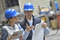 Engineers in mechanical factory reading instructions | Source: ESB Professional / Shutterstock 